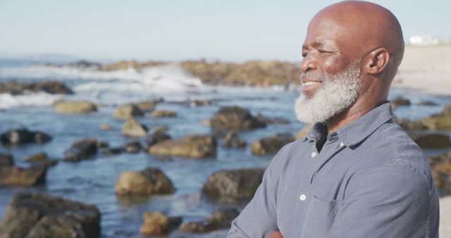 Serene Senior Man Enjoying Time at Rocky Beach with Blue Sky - Download Free Stock Images Pikwizard.com