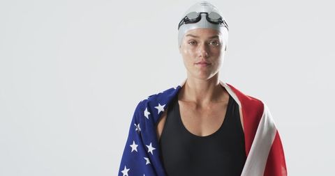 Determined Female Swimmer Draped in American Flag Expressing Patriotism