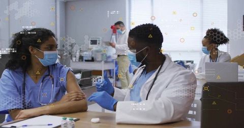 Healthcare professionals administering vaccine in modern clinic