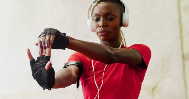 Fitness Enthusiast Stretching with Headphones and Gloves - Download Free Stock Images Pikwizard.com