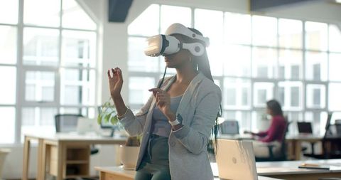 African American Woman Experiencing Virtual Reality in Modern Open-Plan Office
