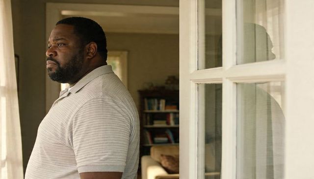 Pensive man gazing through window with soft reflection and home interior mood
