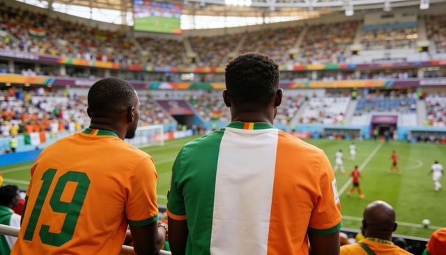 Two football fans leaning on railing watching match in colorful stadium wearing jerseys