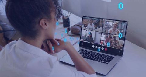 Woman attending remote video meeting on laptop at home desk with digital binary overlay
