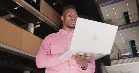 Portrait of Professional Man in Modern Office Atrium with Laptop