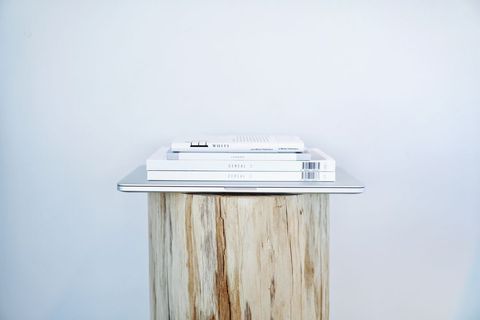 Plain minimalist white books on wooden plinth