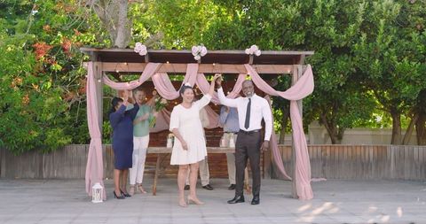 Happy Senior Couple Celebrating Wedding Beneath Floral Pergola