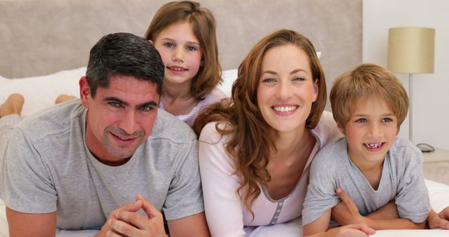 Happy Family Lying on Bed, Smiling at Camera - Download Free Stock Images Pikwizard.com