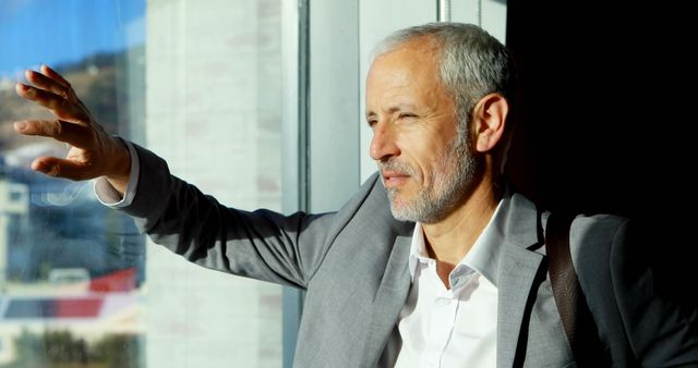 Thoughtful Businessman Looking Out of Window in Bright Office - Download Free Stock Images Pikwizard.com