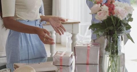 Couple Discussing Near Gift Boxes and Flowers at Home