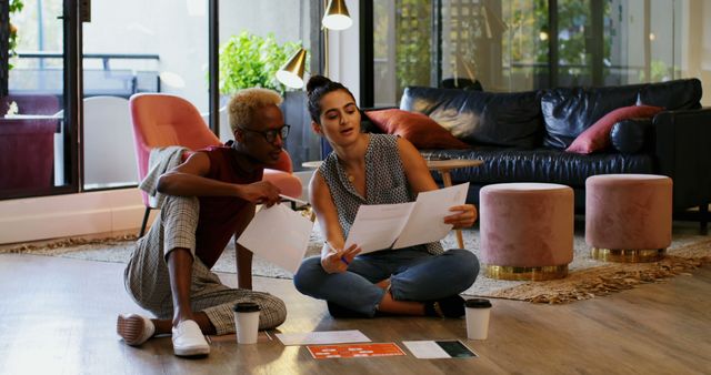 Two Women Reviewing Documents Together in Modern Living Room - Download Free Stock Images Pikwizard.com