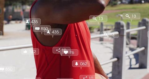 Athletic man holding basketball raising arm to brow outdoors with social media icons