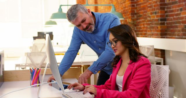 Manager mentoring young employee on computer in trendy loft office - Download Free Stock Images Pikwizard.com