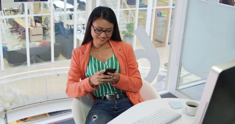 Young Female Professional Using Smartphone in Modern Office