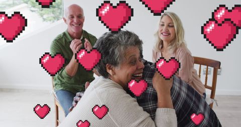 Joyful seniors embracing with pixel hearts overlay