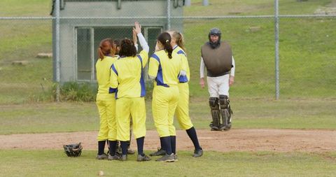 Diverse female softball team celebrating victory