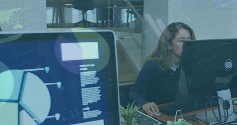 Woman analyzing digital data on screens in modern office
