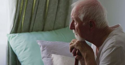 Elderly man reflecting alone at home during covid-19 pandemic