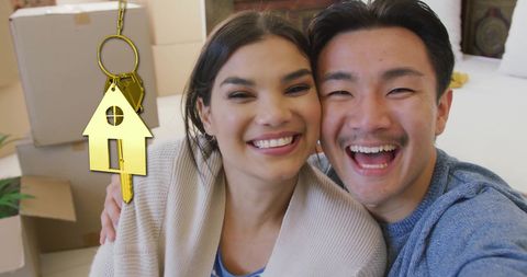 Happy couple celebrating new home with gold key