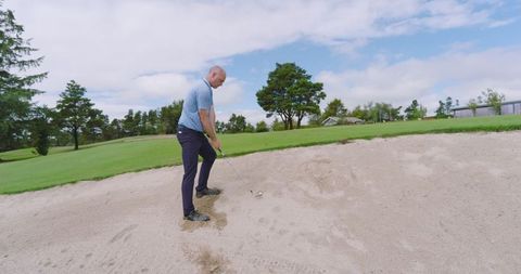 Golfer Skillfully Maneuvering Sand Bunker Shot