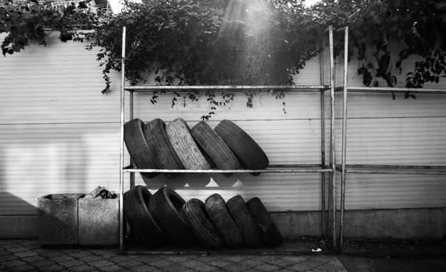 Old tires stacked on metal rack outdoors - Download Free Stock Photos Pikwizard.com