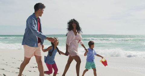 Happy Family Enjoying a Walk on Sunny Beach