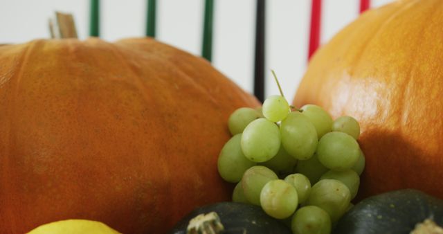 Display featuring fresh green grapes and pumpkins, evoking the atmosphere of the autumn harvest season. Suitable for use in food blogs, organic food advertisements, seasonal decorations, and healthy eating campaigns.