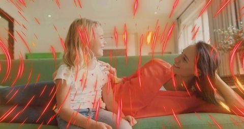 Mother and Daughter Sharing Joyful Moments on Green Sofa