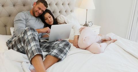 Couple Relaxing with Laptop in Bedroom Setting - Download Free Stock Images Pikwizard.com