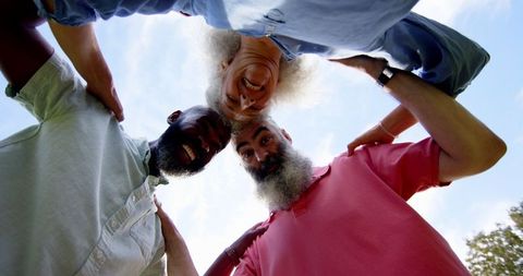 Senior Friends Laughing in Circle Beneath Sunny Sky