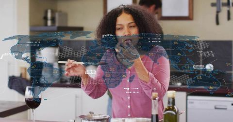 Home cook tasting meal while using augmented reality world map for global food inspiration