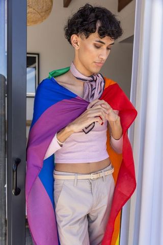 Proud individual wrapped in rainbow flag expressing diversity
