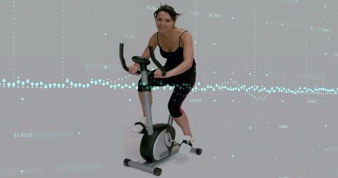 Woman Exercising on Stationary Bike with Data Overlays