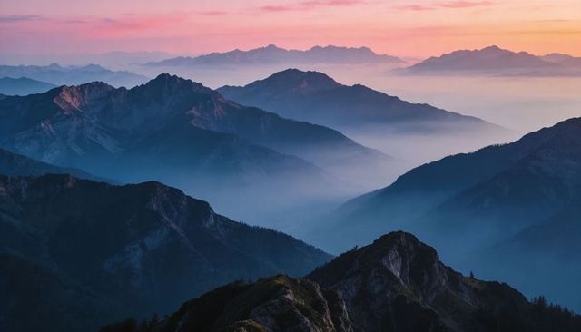 Misty Alpine Ridges at Dawn Showing Layered Mountain Silhouettes and Pastel Sky