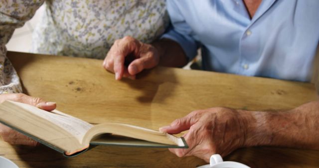 Seniors Reading Together Around Wooden Table - Download Free Stock Images Pikwizard.com