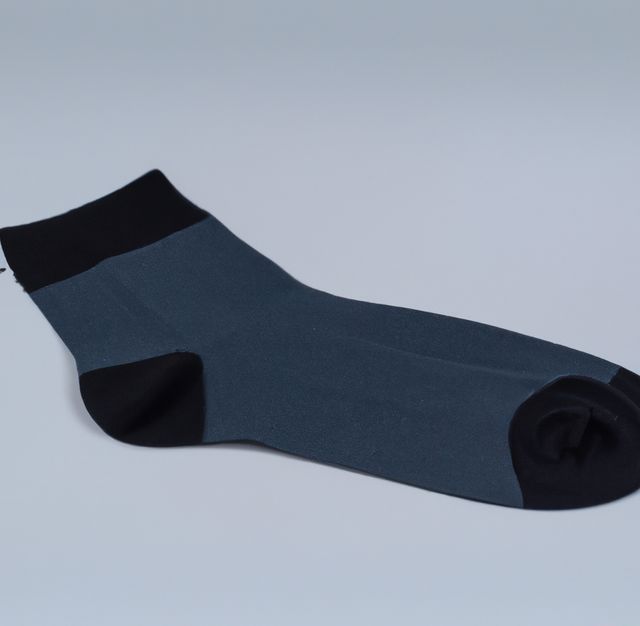 A single gray and black sock lying flat on a white background. This can be used for promotional materials for clothing brands, online retail stores, or equipment tutorials. Ideal for highlighting the simplicity and style of casual or everyday socks, emphasizing the minimalist design suitable for both men and women.