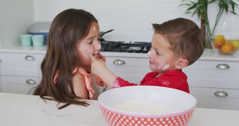 Playful Siblings Baking Together in Modern Kitchen