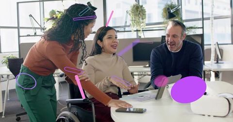 Diverse team collaborating around tablet in accessible open-plan office