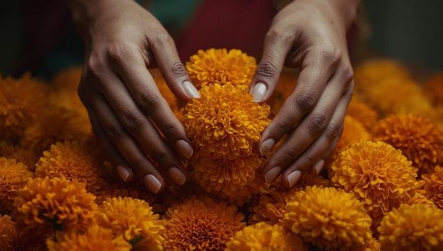 Hands arranging lush orange marigolds with elegant floral detail