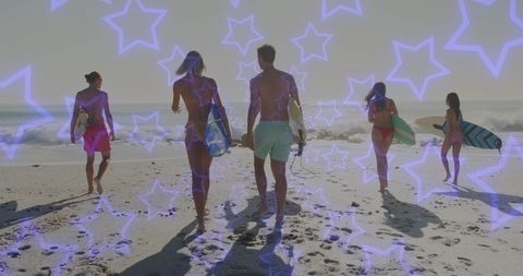 Group of Surfers Walking Towards Ocean at Sunset