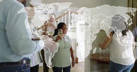 Multigenerational adults raising wine glasses and clinking at home with world map overlay