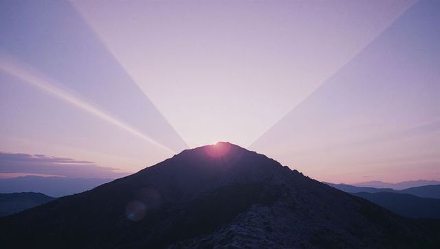 Sunrise Over Mountain Ridge Creating Radiant Sunbeams