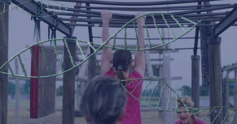 Woman on outdoor adventure park monkey bars
