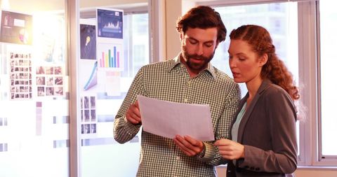 Business executives analyzing documents in modern office