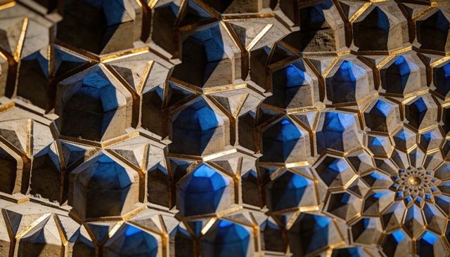 Muqarnas vault radiating toward star rosette, gilded geometry with blue accent lighting