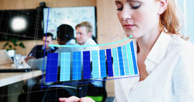 Businesswoman using augmented reality technology to analyze data charts in an office environment. This can be used for articles and presentations focused on modern business practices, augmented reality, data-driven decision-making, and innovative technology in the workplace.