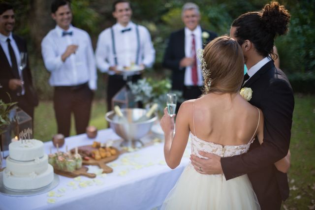 Rear view of newly married couple holding glasses of champagne