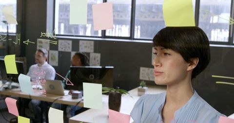 Executive Pondering Strategy with Sticky Notes in Modern Office