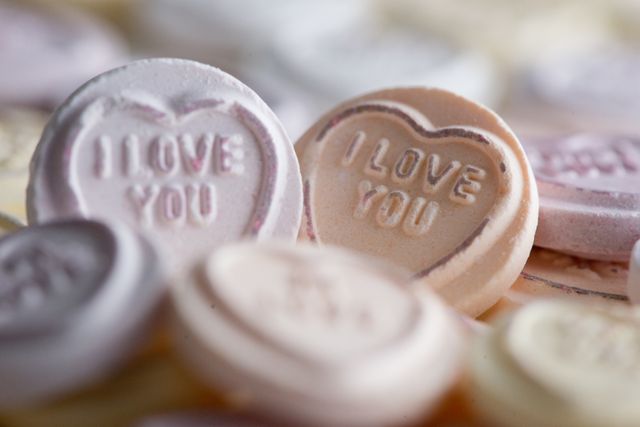 Image shows a close-up view of candy hearts embossed with 'I Love You' message. Perfect for Valentine's Day themes, love and romantic concepts, greeting card design, and celebratory marketing materials.