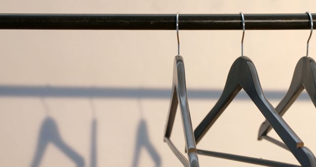 Empty Wooden Hangers Hanging on Rail in Minimalist Setting - Download Free Stock Images Pikwizard.com